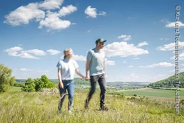 Paar (unscharf) macht einen Streifzug über den Berg mit Blick runter nach Bubenheim/Wettelsheim