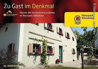 Häuser, die Geschichte erzählen - laden ein zu Wohnen und genießen in historischen Mauern. Ein typisches Jurahaus mit grüner Tür und Fenster mit Blumenkästen zeigt die Broschüre.