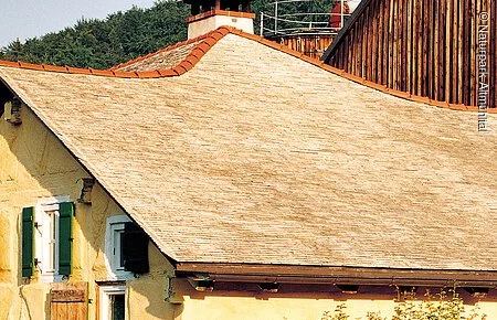 Ein typisches Jurahaus mit Schieferlegdach und grünen Fensterläden. Links vorne gehts in den Garten und rechts am Haus wurden zwei kleine Bäumchen gepflanzt.