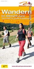 Tourenheft mit großer Wanderkarte. Zudem sind auf der Wanderkarte drei Wanderer mit Rucksäcken zu sehen.