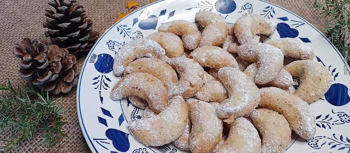 ein Teller mit Vanillekipferl, weihnachtlich dekoriert