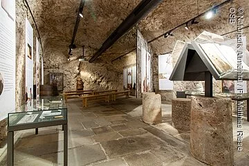 Der Ausstellungsraum ist im Untergeschoss. Es sind einige Tischvitrinen und weitere Exponate zu sehen. Der Felsenkeller wurde in den Naturfels ausgeschlagen.