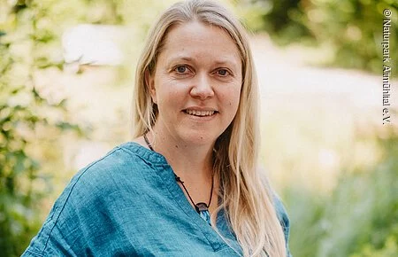 Andrea Spranger Frau mit blauem Oberteil vor grünem Hintergrund