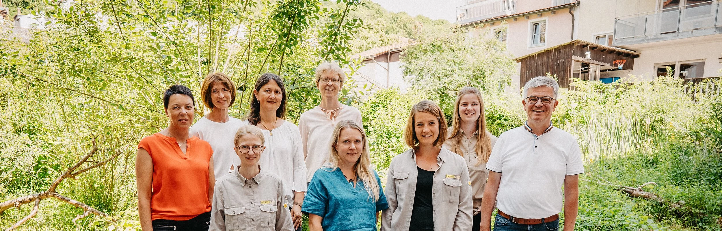 Personengruppe vor grünem Hintergrund