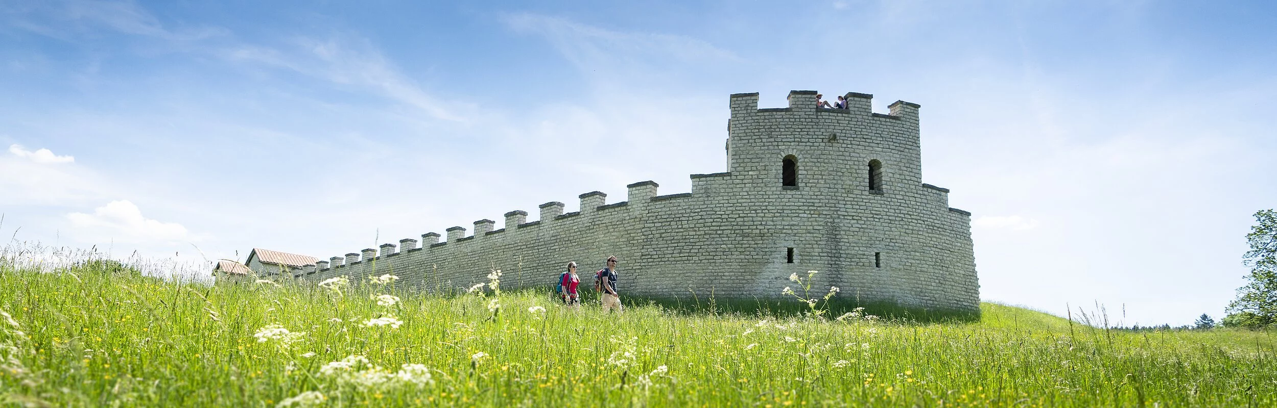 Das Römerkastell rekonstruiert mit weißen Steinen inmitten einer grünen Wiese.