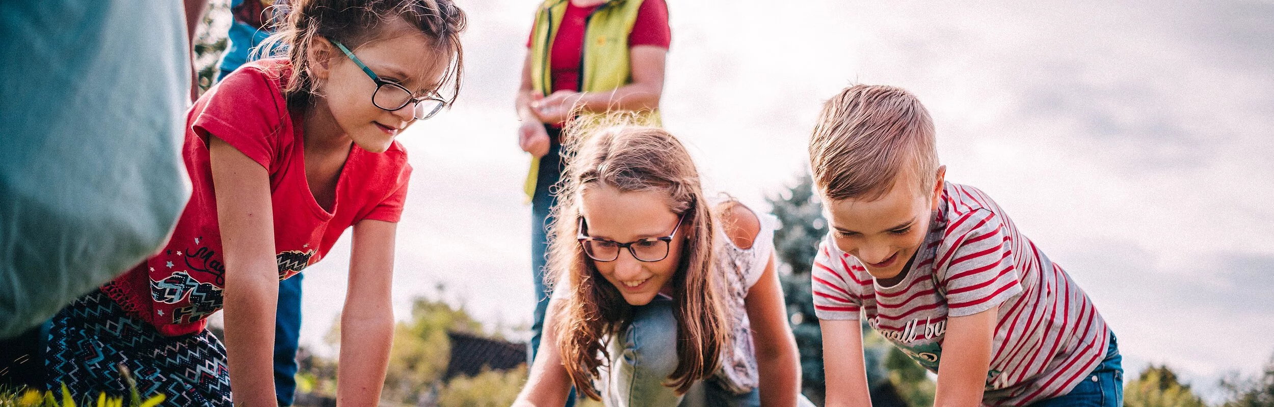 Kinder sitzen spielend am Boden