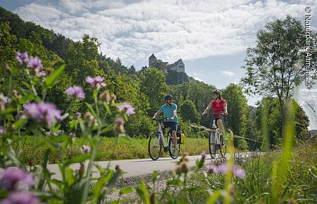 Radfahrer bei Nusshausen mit Burg Prunn im Hintergrun