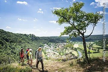 Familie mit Rangerin auf der sommerlichen Arnsberger Leite mit Talblick im Hinergrund. 