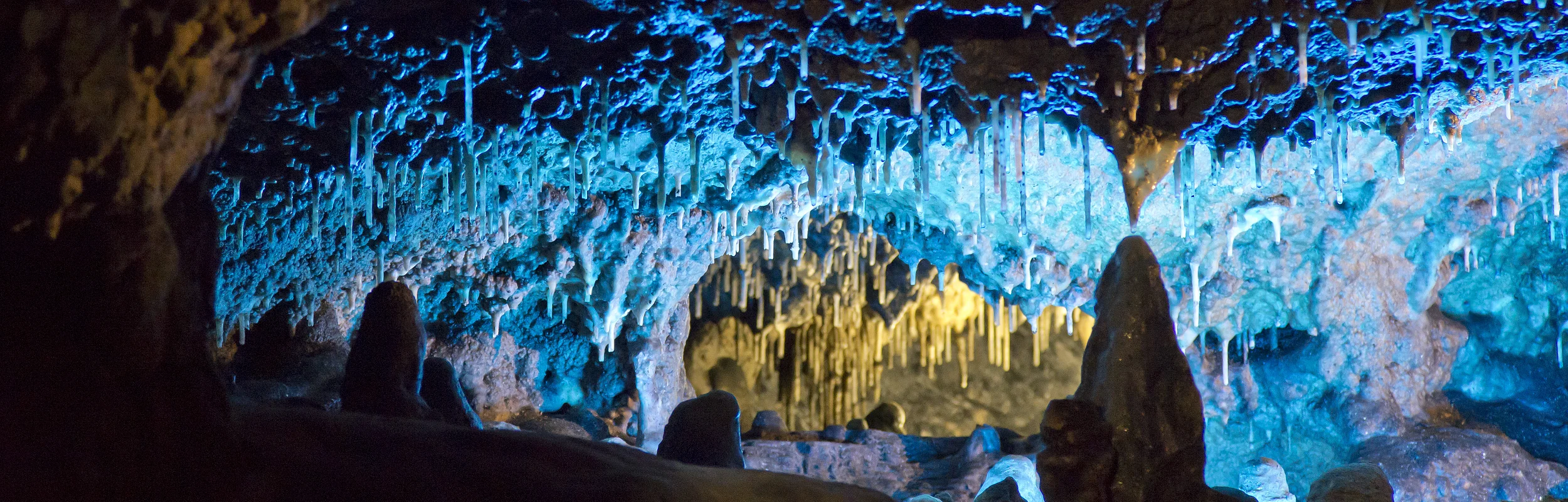 Die Tropfsteinhöhle mit ihren Stalagniten blau ausbeleuchtet.