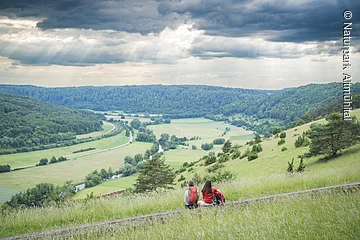 Lange Bank 2 Wanderer sitzen auf der langen Bank bei Obereichstätt und genießen den Weitblick ins Tal