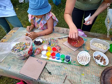 Kinder basteln Kind bastelt mit Holzstäbchen und bunten Farben kleine Igel