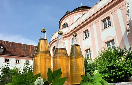 Einige Flaschen Kräuterlimonade, im Hintergrund das Infozentrum
