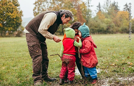 Ranger mit Kindern vor Wasserpfütze