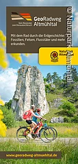 Ein Plakat für den GeoRadweg Altmühltal zeigt zwei Radfahrer vor einer großen Felsformation. Text und Logo des Naturparks Altmühltal sind sichtbar.