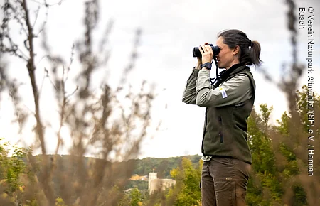 weibliche Person mit Fernglas