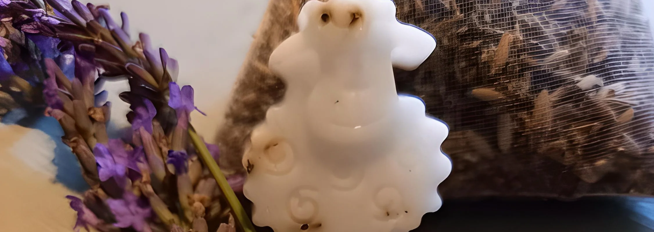 Eine Lavendelseife in Schäfchenform liegt auf einem Tisch, dekoriert mit blühendem Lavendel