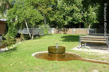 Brunnen am Mühlbach mit Sitzbänken